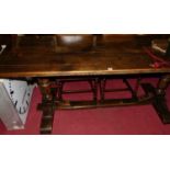 An early 20th century oak and elm plank topped refectory dining table, having rounded cleated
