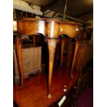 A figured walnut and crossbanded shaped bowfront hall table, raised on slender shell-capped cabriole