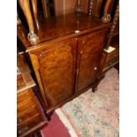 A figured walnut and crossbanded double door side cupboard, on squat shell-capped cabriole supports,