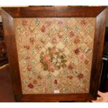 A Victorian woolwork depicting floral sprays within latticework borders, all in a glazed rosewood