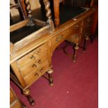 An early 20th century oak kneehole writing desk, having a black rexine inset surface over an