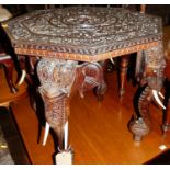 A circa 1900 Indian heavily relief carved teak octagonal occasional table, the top surface floral