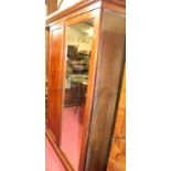 A Victorian mahogany double door wardrobe, the mirrored door and panelled door enclosing hanging