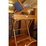 A contemporary stained beech twin handled butler's tray, on X-frame bamboo effect folding stand;