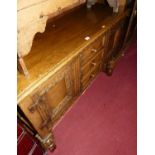 A possibly Titchmarsh & Goodwin moulded and relief carved oak dresser base, having three central