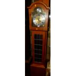 A contemporary hard wood long case clock, having an arched brass and silvered dial titled Tempus
