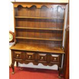 A 17th century style joined oak dresser, the later three-tier plate rack over base fitted with