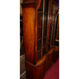 A walnut and figured walnut bookcase cupboard in the Queen Anne taste, having twin glazed upper