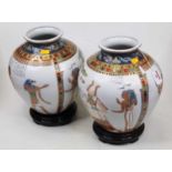 A pair of modern Egyptian style vases, each of squat circular form, on a white ground, incised and