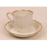 A late 18th/early 19th century Worcester porcelain teacup and saucer of fluted form on a white