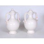 A pair of continental white crackle glazed pottery urns, each of baluster form and flanked by
