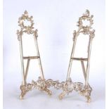 A pair of reproduction brass table easels in the Rococo taste, with rocaille and C-scroll