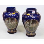 A pair of early 20th century vases, each of baluster form, on a blue ground printed with four