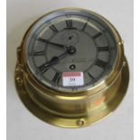 A brass cased ships clock, the circular silvered dial with Roman numerals, Arabic outer numerals and
