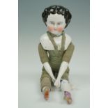 A 19th Century German import china head and shoulder doll, on a green checked cloth body with glazed