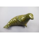 An Inuit carved green serpentine sculpture of a seal by Noah-Aglak, 18 cm