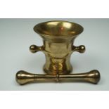 An antique brass pestle and mortar, latter 11 cm high