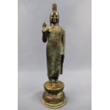 A patinated bronzed statue of a standing Buddha, 20th Century, 32 cm