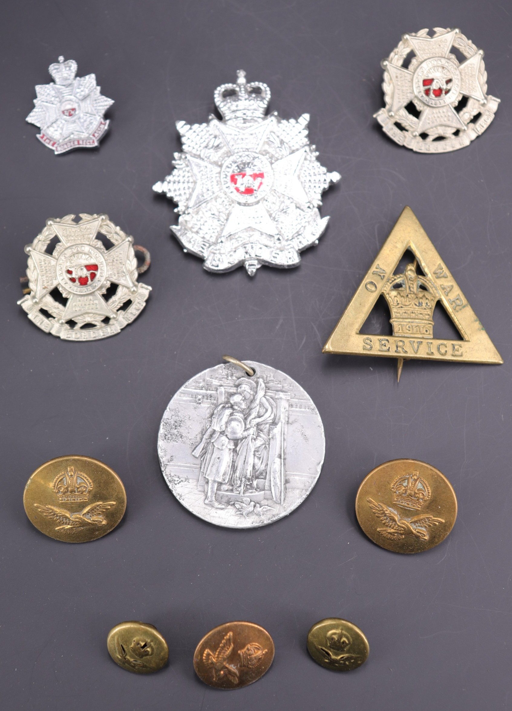 Sundry items of military insignia including a 1916 On War Service lapel badge, a Border Regiment