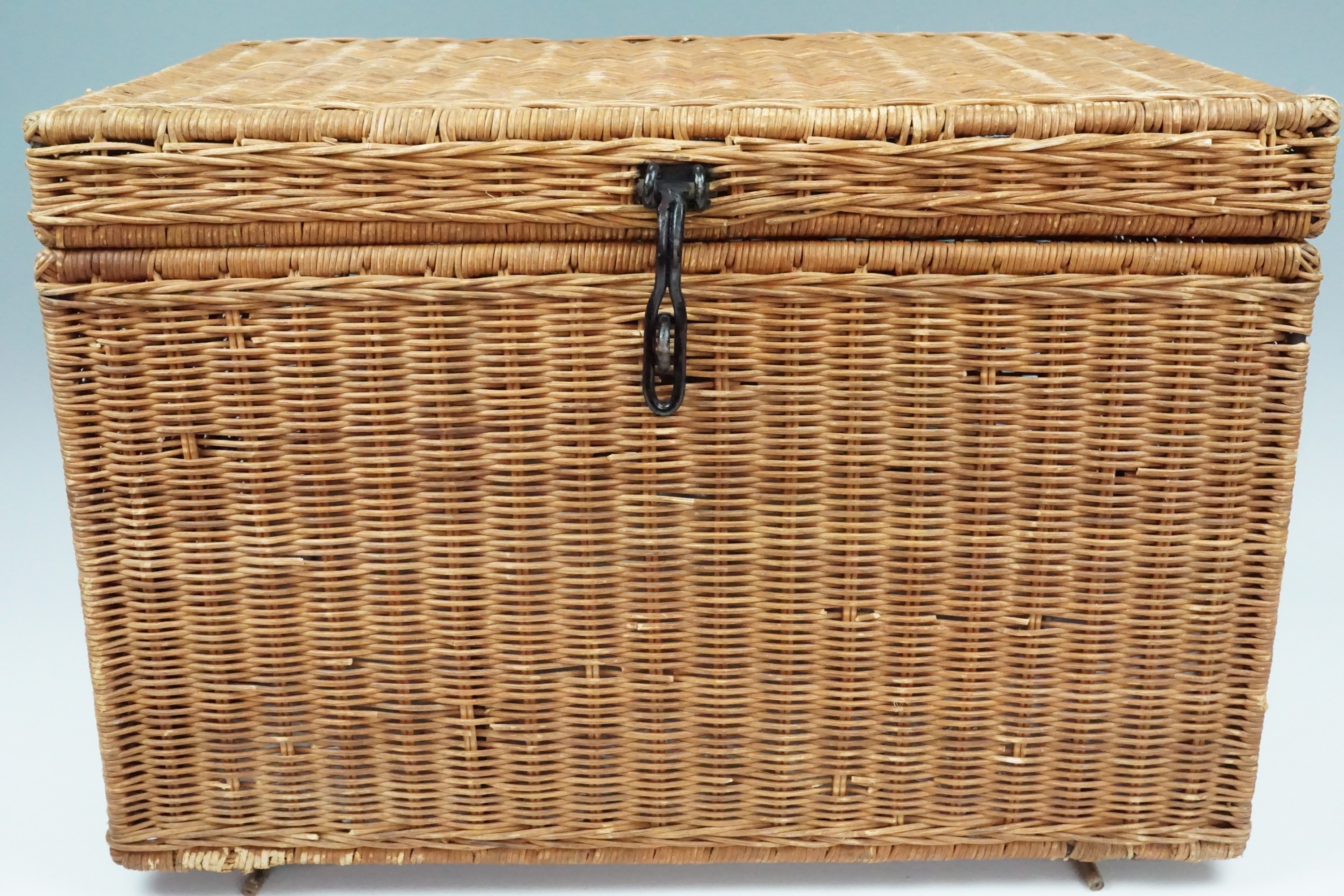 A woven box containing a large quantity of new-old-stock and as-new vintage babies' clothing,