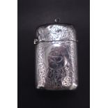A late Victorian silver fob Vesta case, of cushion form, densely ivy leaf engraved and faced with