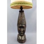 A large African carved hardwood table lamp modelled as a bust, 42 cm to socket