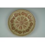 An earthenware shallow bowl decorated with floral sgraffito work through a cream slip, 41 cm