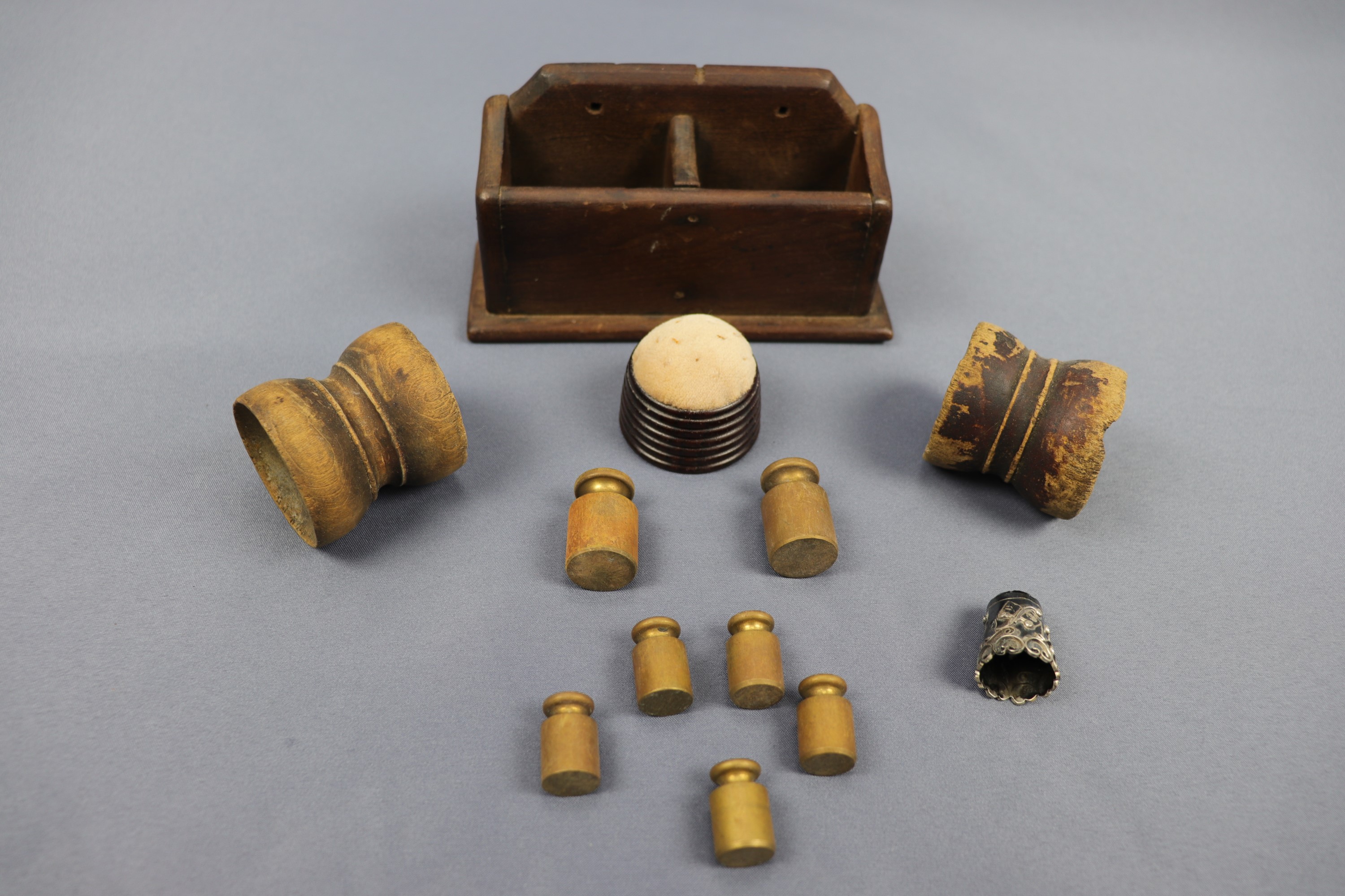 Sundry collectors' items including brass weights, a turned wooden pin cushion, white metal thimble