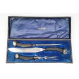 A cased early 20th Century silver-collared carving set