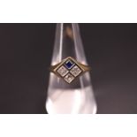 A diamond and blue stone ring, having a square face divided into four cells, one set with a square