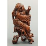 A Chinese root wood carving of a laughing Buddha type figure, 18 cm