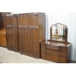 A mid-20th Century three-piece panelled oak bedroom suite