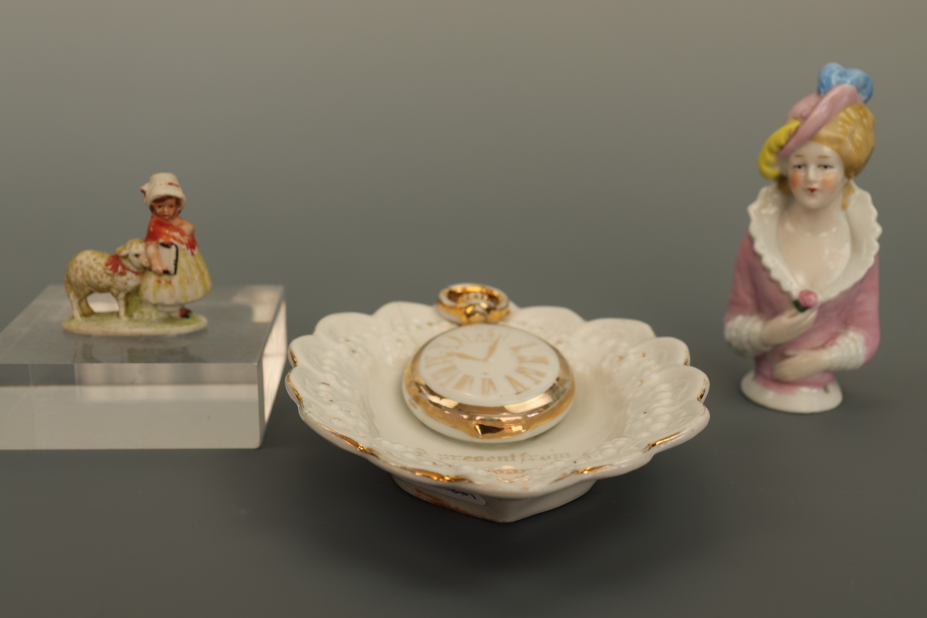 A Belle-Epoque porcelain pin lady together with a souvenir of Edinburgh (a/f) and a bisque porcelain