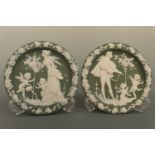 A pair of continental porcelain wall plaques, in the style of green Jasperware, depicting romantic