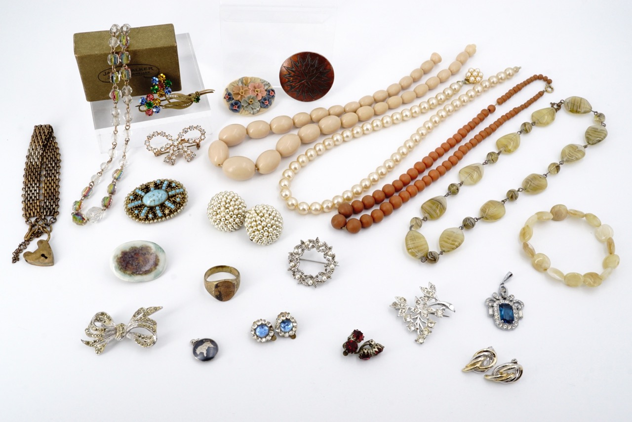 A quantity of vintage costume jewellery, including a brooch in a "James Walker The London Jeweler"