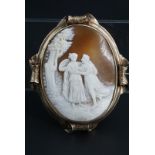 A large Victorian shell cameo brooch, the oval cameo carved in depiction of a romantic vignette,