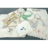 A quantity of vintage colourful hand-embroidered table linens, including cloths, napkins and