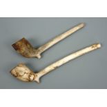 Two 19th Century military clay pipes, one having a bowl decorated with martial trophies, the other