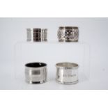 Four silver napkin rings, one reticulated and engraved with a monogram, Chester, 1903, one