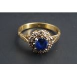 A sapphire and diamond flowerhead cluster ring, the central sapphire of approximately .65 ct claw
