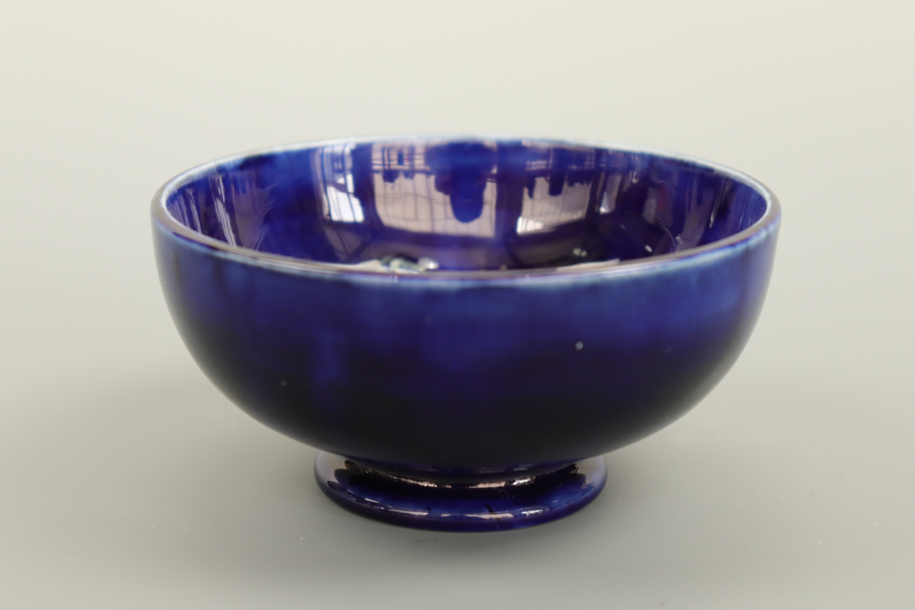 A William Moorcroft footed bowl, of circular section, decorated with a pansy over a cobalt blue - Image 2 of 2