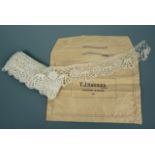An antique run of bobbin lace, in a T J Harries of Oxford Street, London paper bag