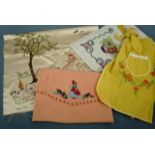 Vintage needlework items including yellow cotton half-apron embroidered with flowers, a peach felt