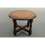 An hide-upholstered oak stool, 40 cm diameter x 32 cm high
