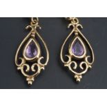 A pair of amethyst and yellow metal ear pendants, comprising pendeloque gems sets within openwork