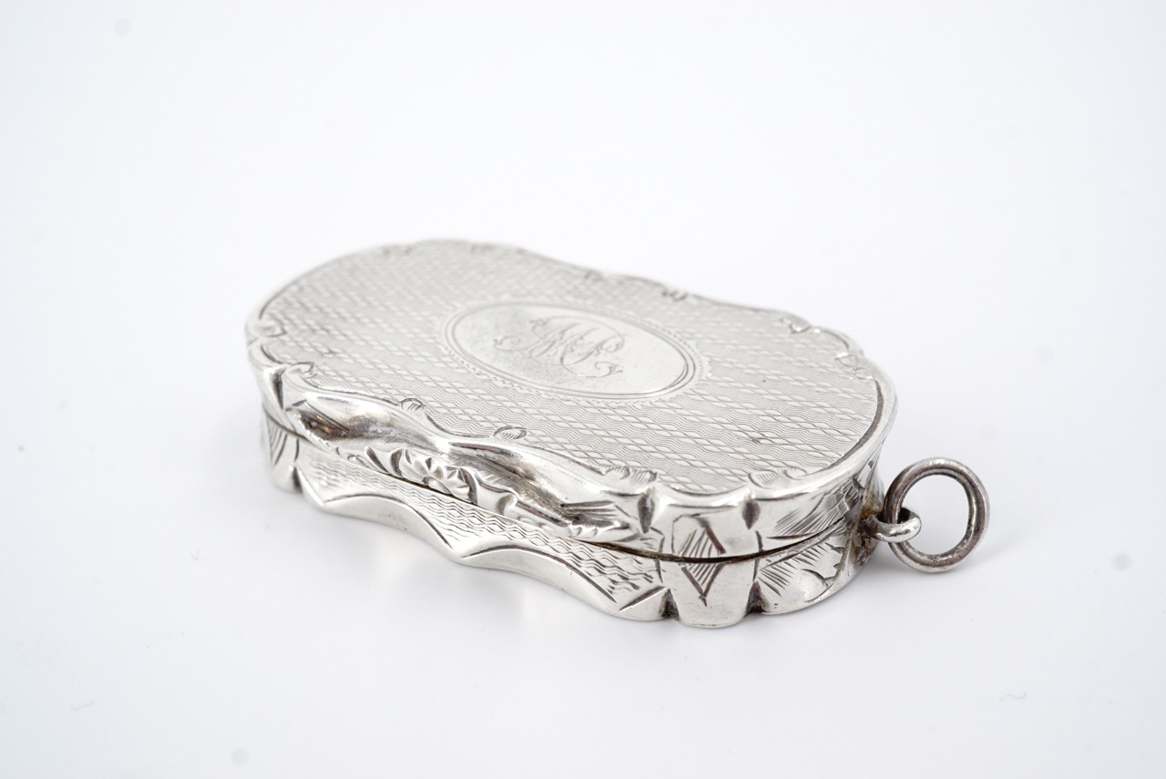 A Victorian silver fob vinaigrette, of oval section with a cusped rim and engraved sides, the covers - Image 2 of 3