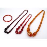 A quantity of faux butterscotch and faux cherry amber jewellery, comprising three necklaces and a