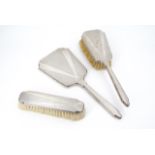 A 1930s silver Art Deco dressing table mirror and brush set, three piece, with guilloche engraved