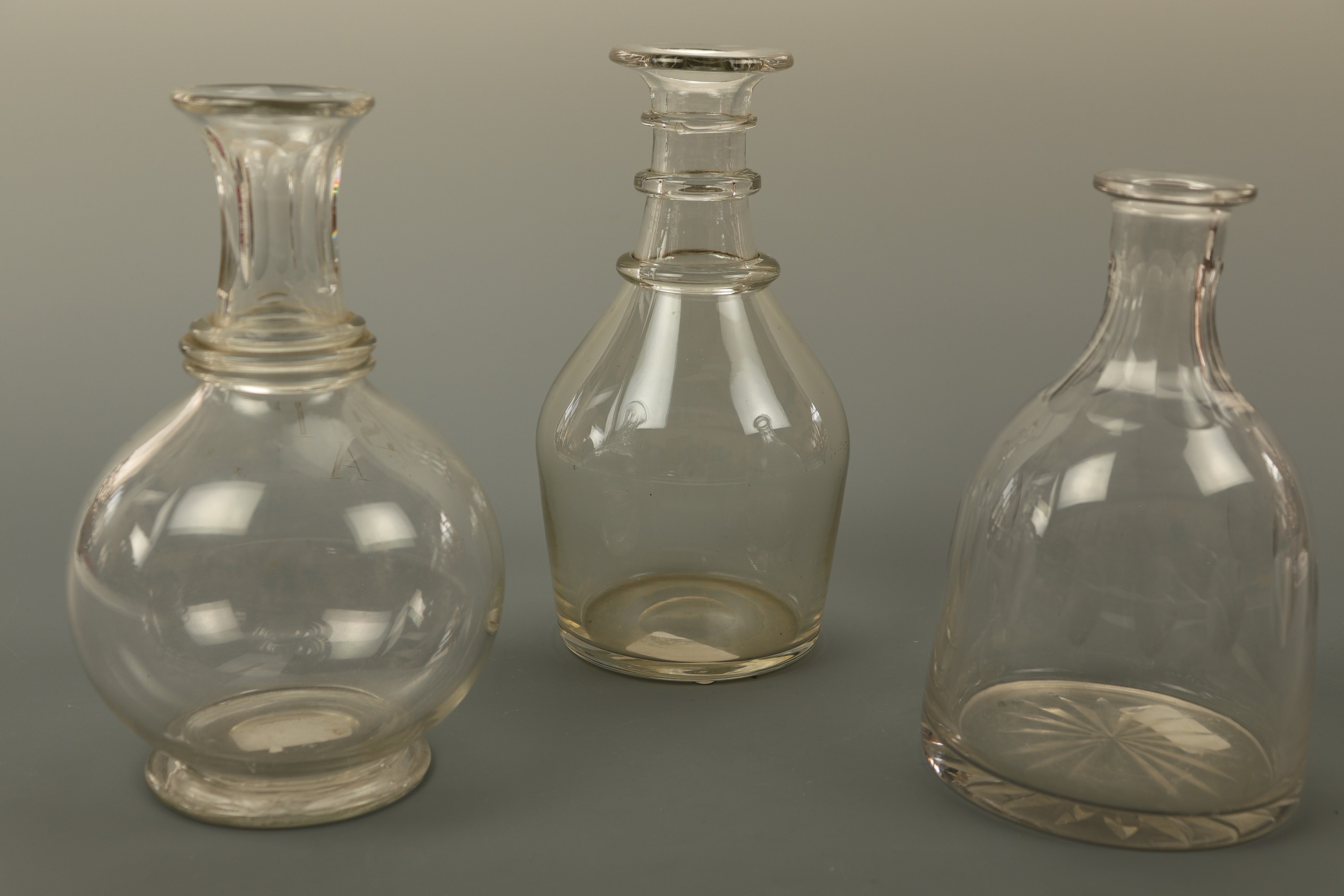 A Georgian Prussian bodied decanter and two later examples