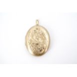 A 9 ct gold pendant locket, oval and foliate-scroll engraved, 4.5 cm excluding suspender, 16.8 g